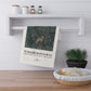 Tea towel with nature design and 'William Morris & Co' text hanging on a shelf.