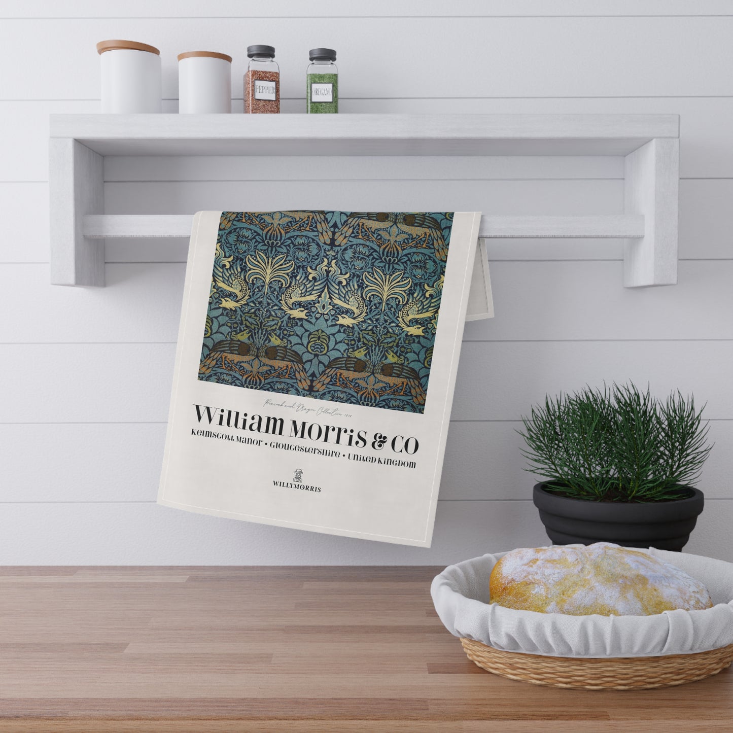 Decorative towel with William Morris & Co design hanging on a shelf in a kitchen setting.