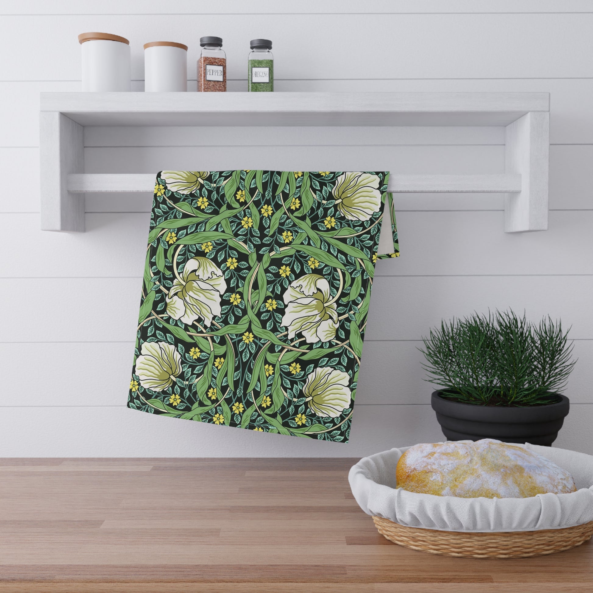 A kitchen tea towel with a green background and a floral pattern inspired by William Morris - Pimpernel Collection.
