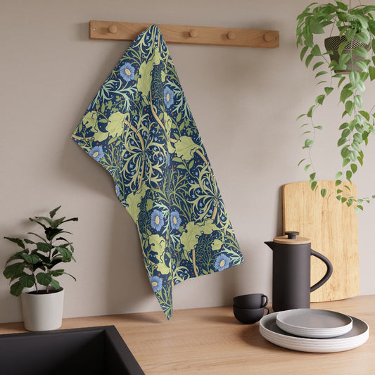 A rectangular kitchen tea towel featuring a floral Arts & Crafts pattern from William Morris & Co with blue flowers and green leaves on a cream background.