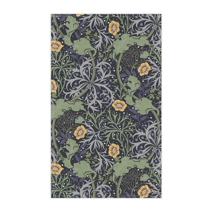 A rectangular kitchen tea towel featuring a repeating pattern of seaweed and yellow flowers on a green background.