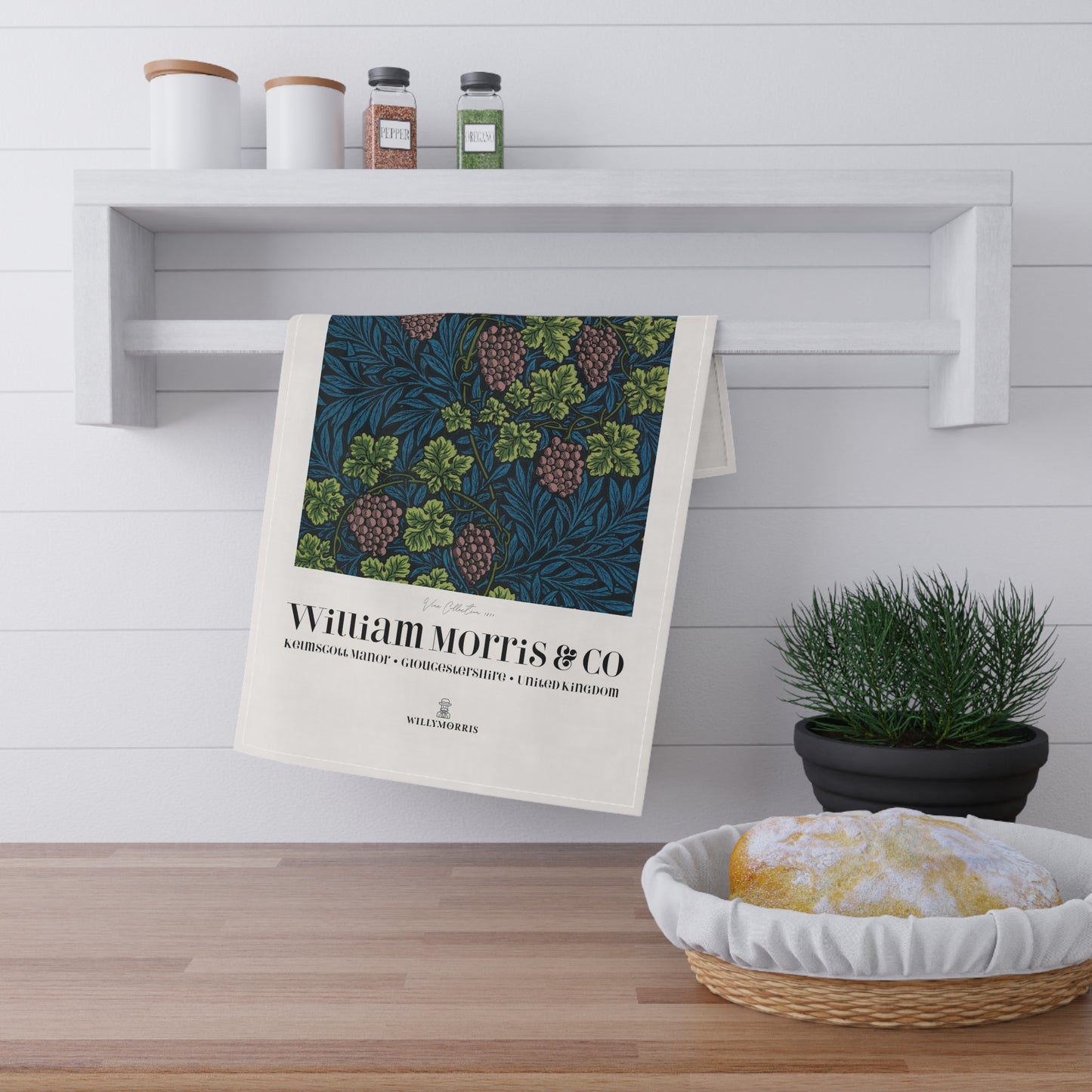 Decorative towel with William Morris & Co design hanging on a shelf in a kitchen setting.