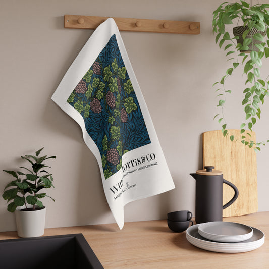 Tea towel with nature design hanging on a wooden rack in a kitchen setting.