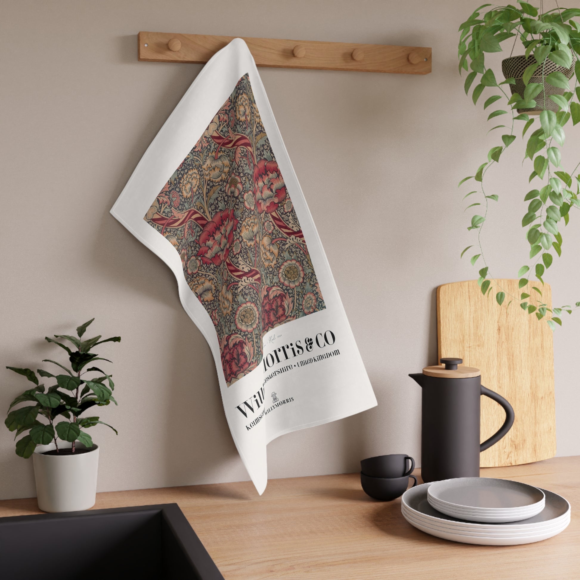 Decorative towel with floral pattern hanging on a wooden rack in a kitchen setting.