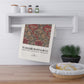 Decorative towel with floral pattern and 'William Morris & Co' text hanging on a shelf in a kitchen.