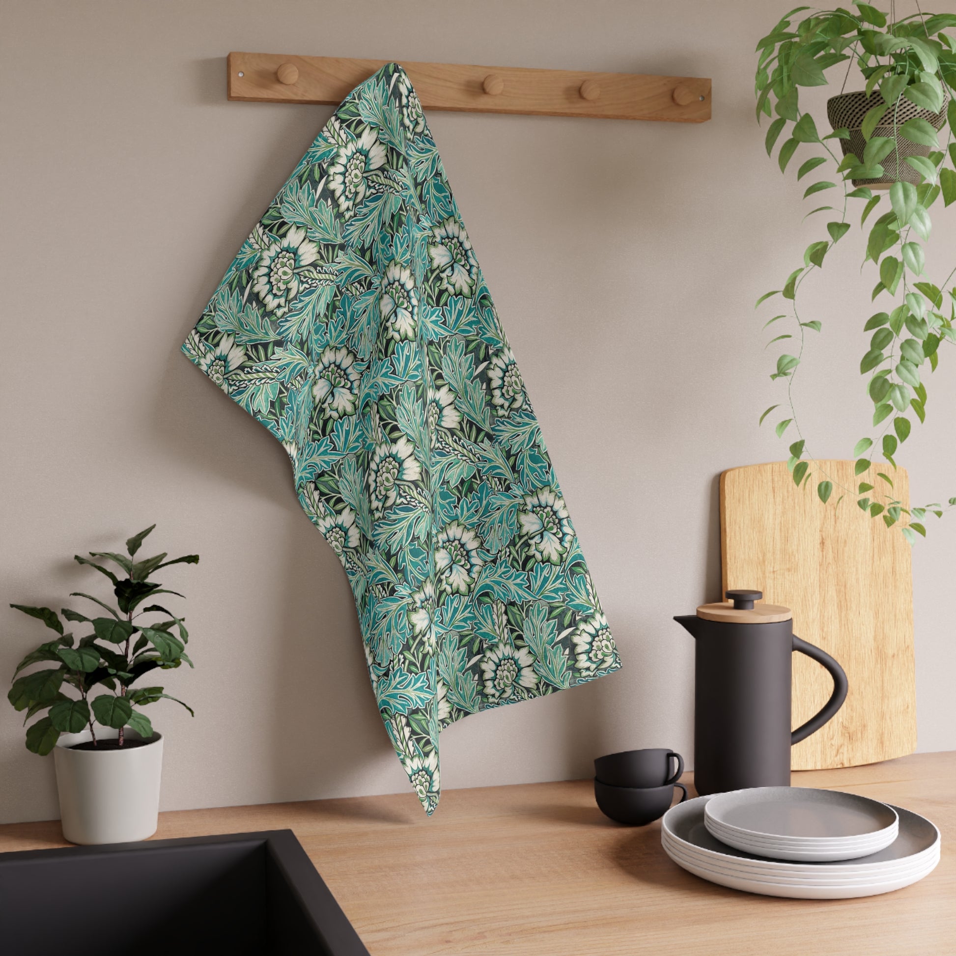 A kitchen tea towel with a floral pattern inspired by William Morris, in shades of blue, green, and white.