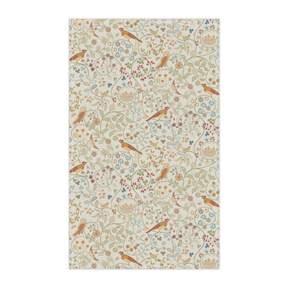 Decorative tea towel with floral and bird pattern on a white background