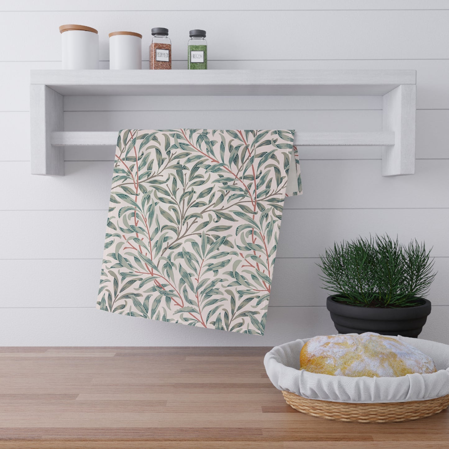 Striped towel hanging on a wooden shelf with a plant and basket in the foreground.