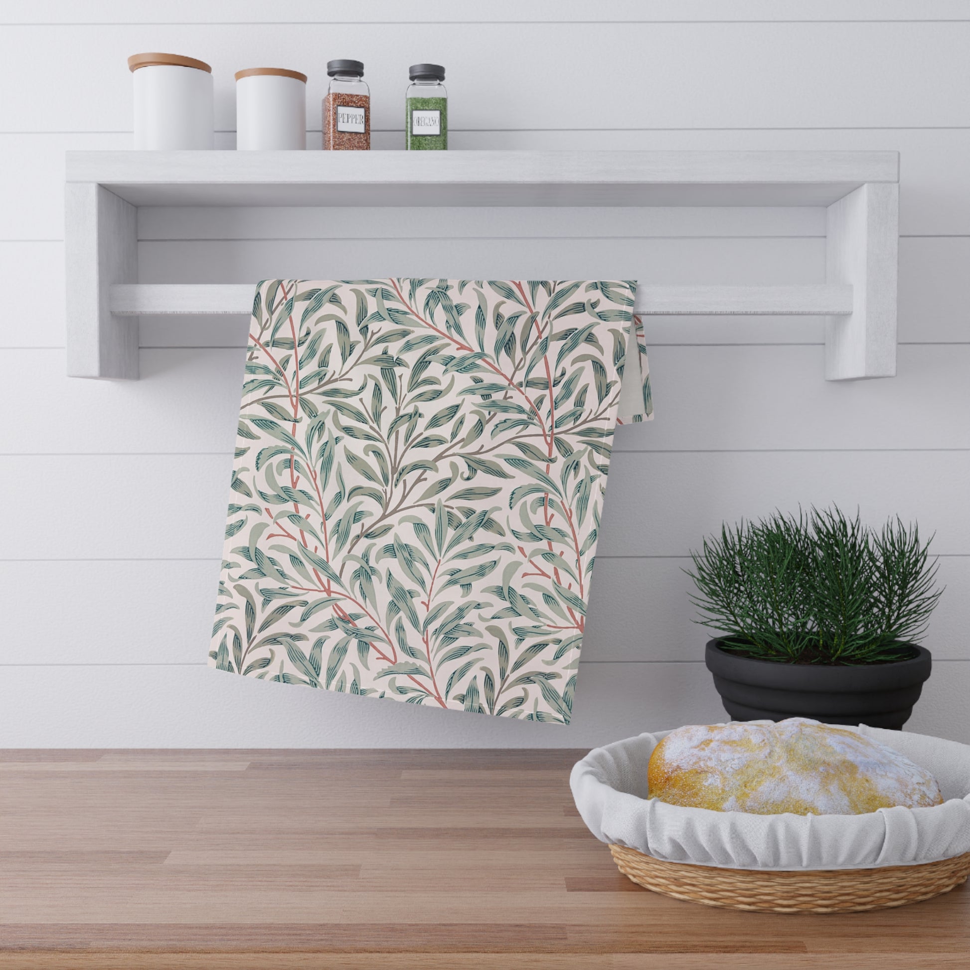 Striped towel hanging on a wooden shelf with a plant and basket in the foreground.