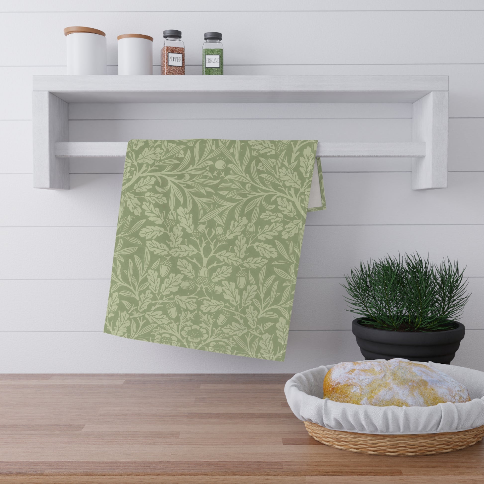 A green kitchen tea towel with a floral and leaf pattern inspired by William Morris & Co - Acorn and Oak Leaves Collection.
