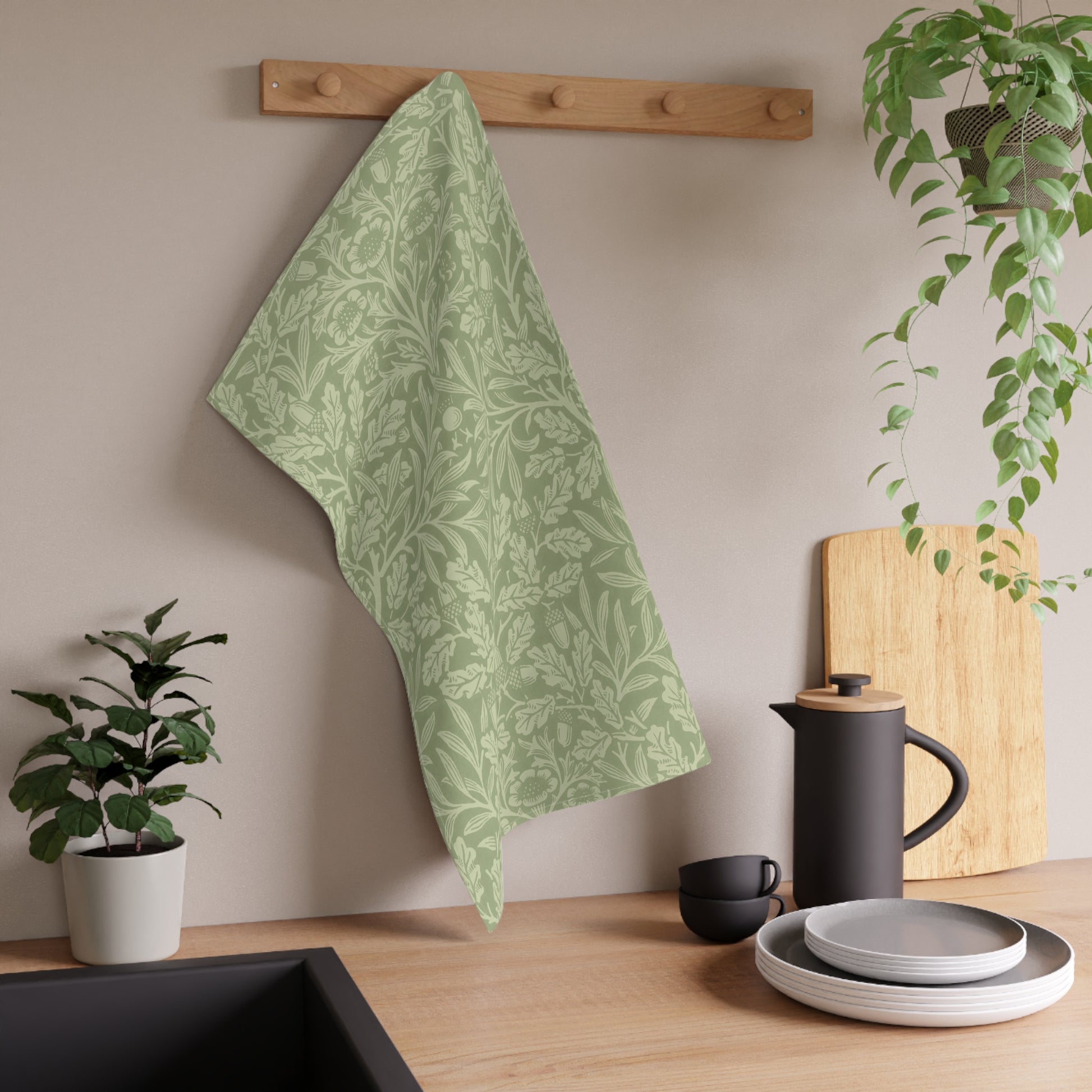 A green kitchen tea towel with a floral and leaf pattern inspired by William Morris & Co - Acorn and Oak Leaves Collection.