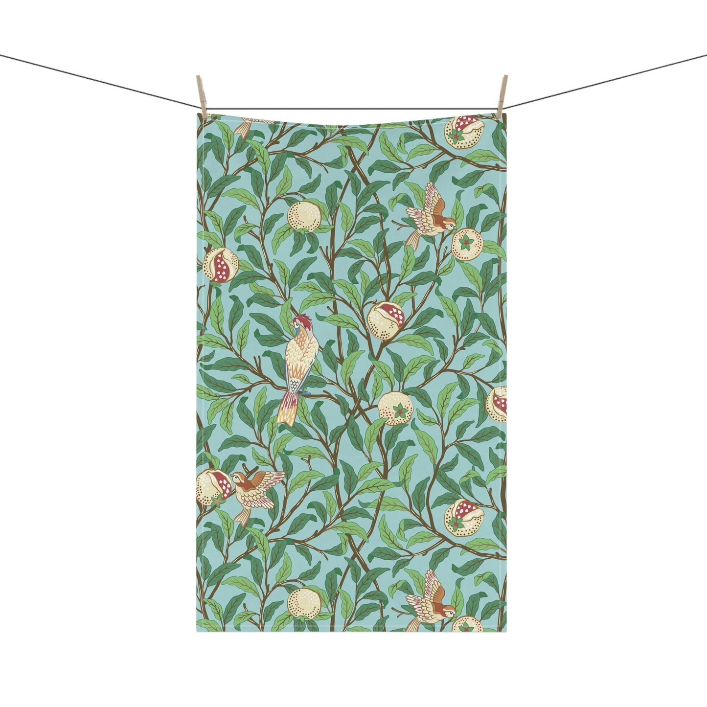 A kitchen tea towel with a blue background featuring bird and pomegranate patterns inspired by William Morris.