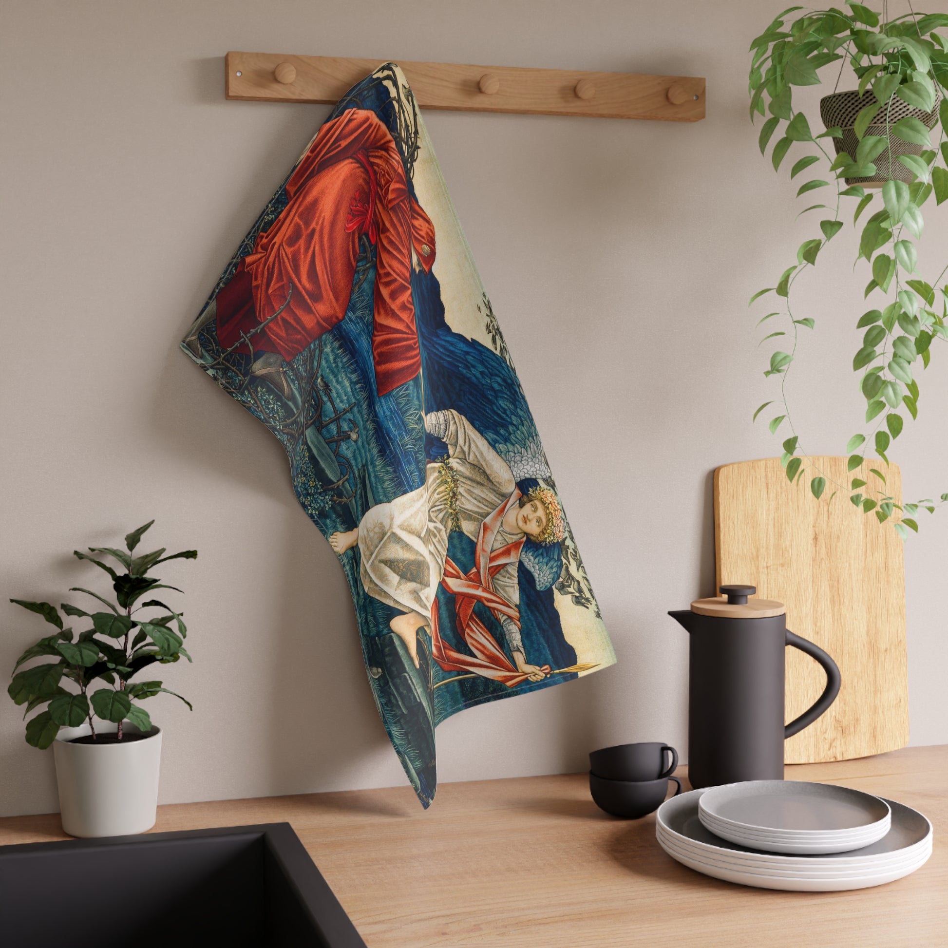 A kitchen tea towel featuring a vibrant, William Morris & Co artistic design with a figure in red and another in white, set against a blue background with greenery.