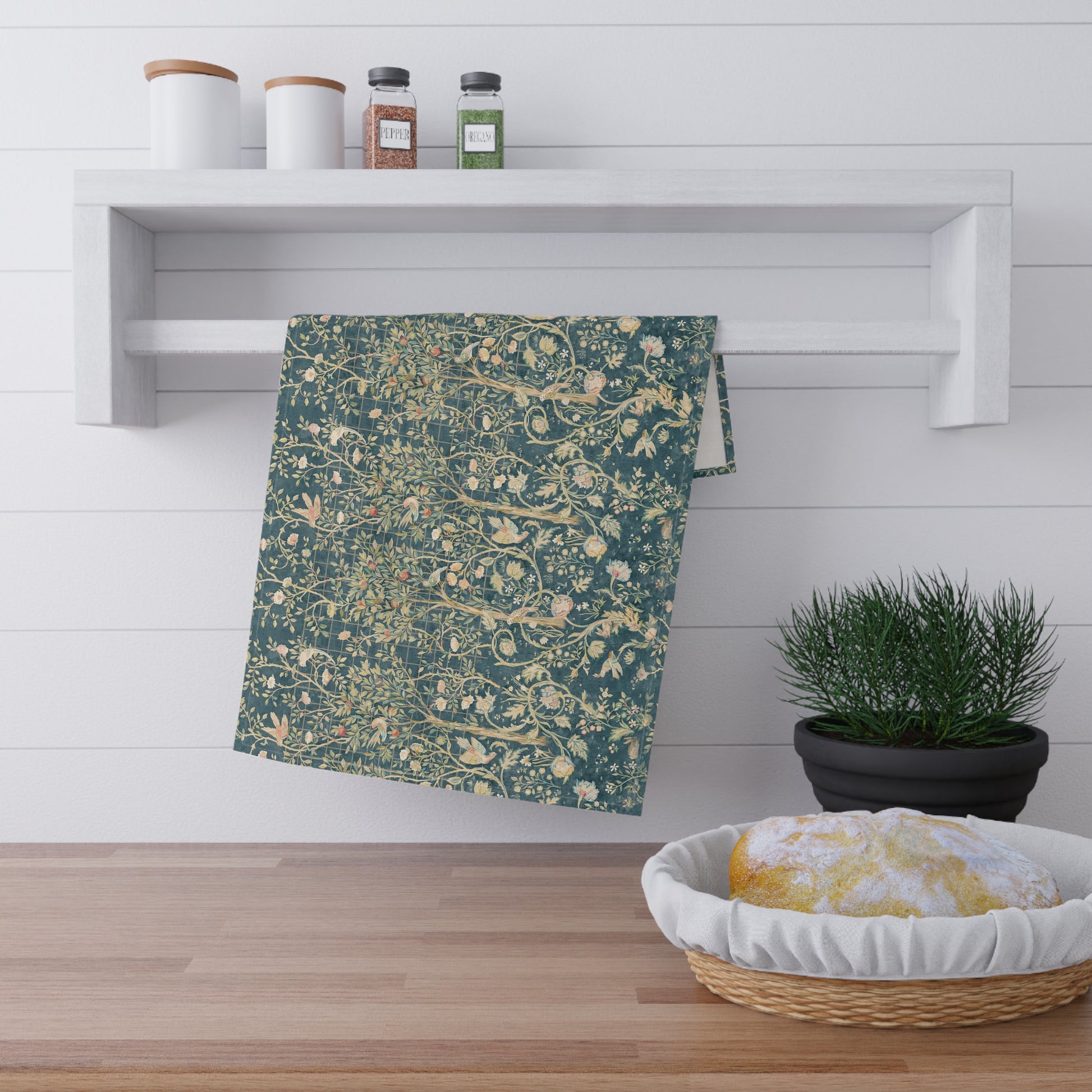A rectangular kitchen tea towel with a floral and bird pattern in a teal colour inspired by William Morris & Co.