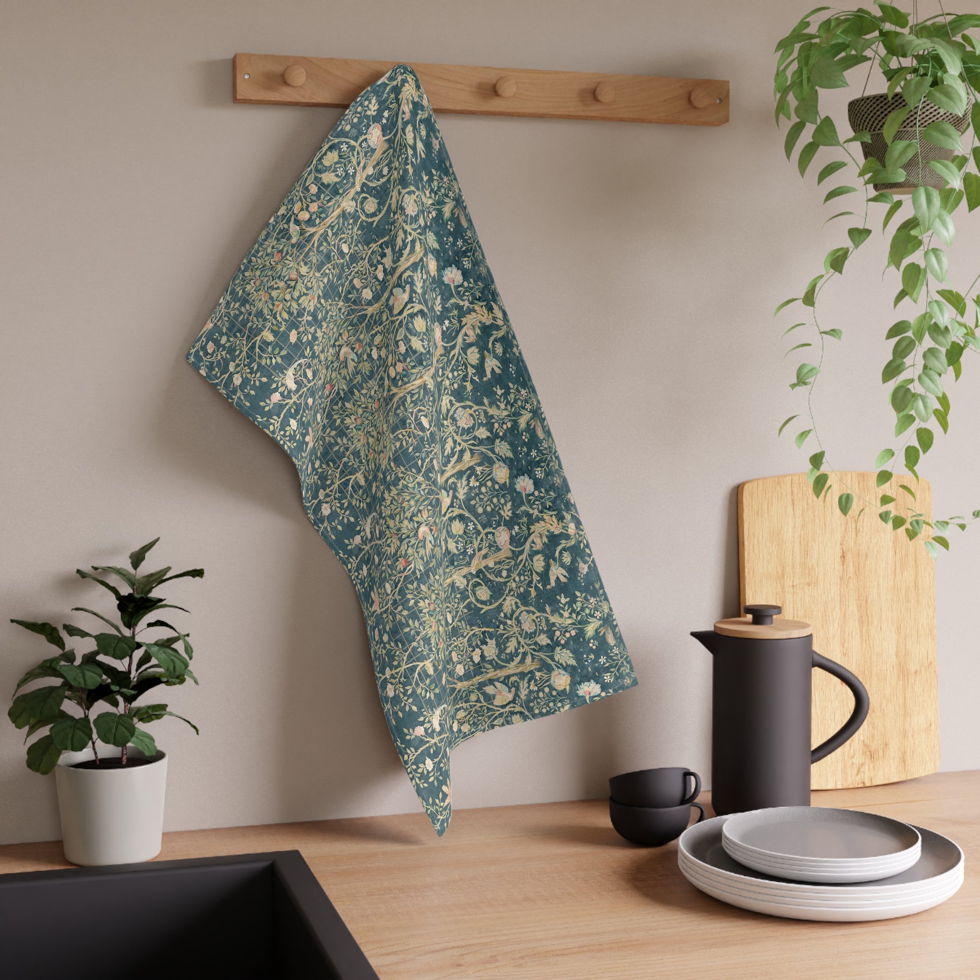 A rectangular kitchen tea towel with a floral and bird pattern in a teal colour inspired by William Morris & Co.