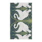 A kitchen tea towel featuring a repeated pattern of a white swan with a green and brownish background, and a set of dishes with cutlery on the side.