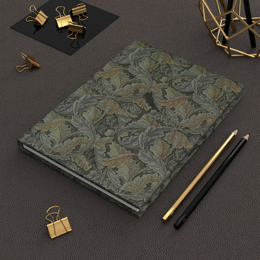 Floral patterned notebook with gold clips and pencils on a dark surface
