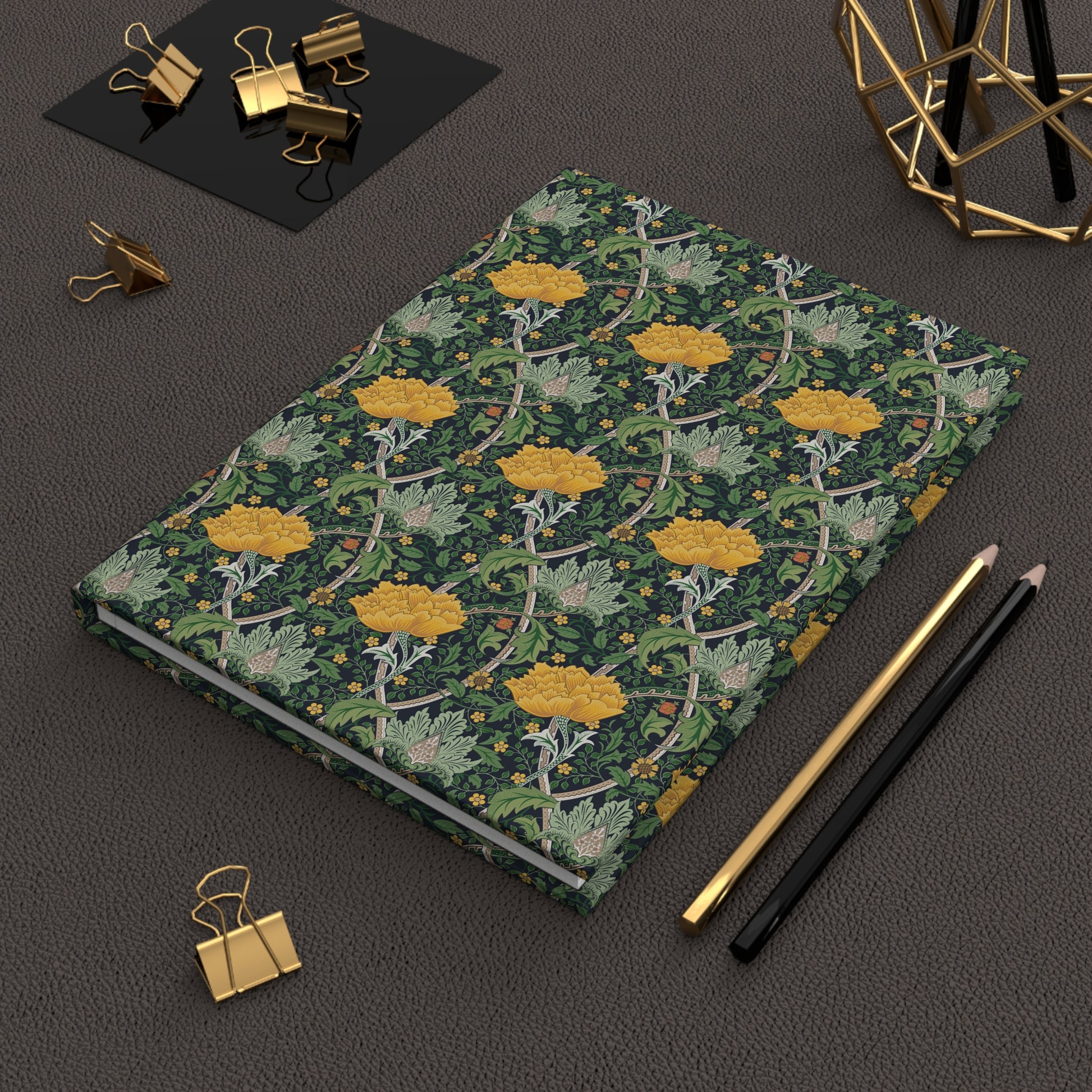 Notebook with floral design on a dark surface with office supplies