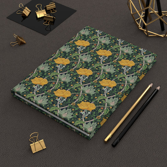 Notebook with floral design on a dark surface with office supplies