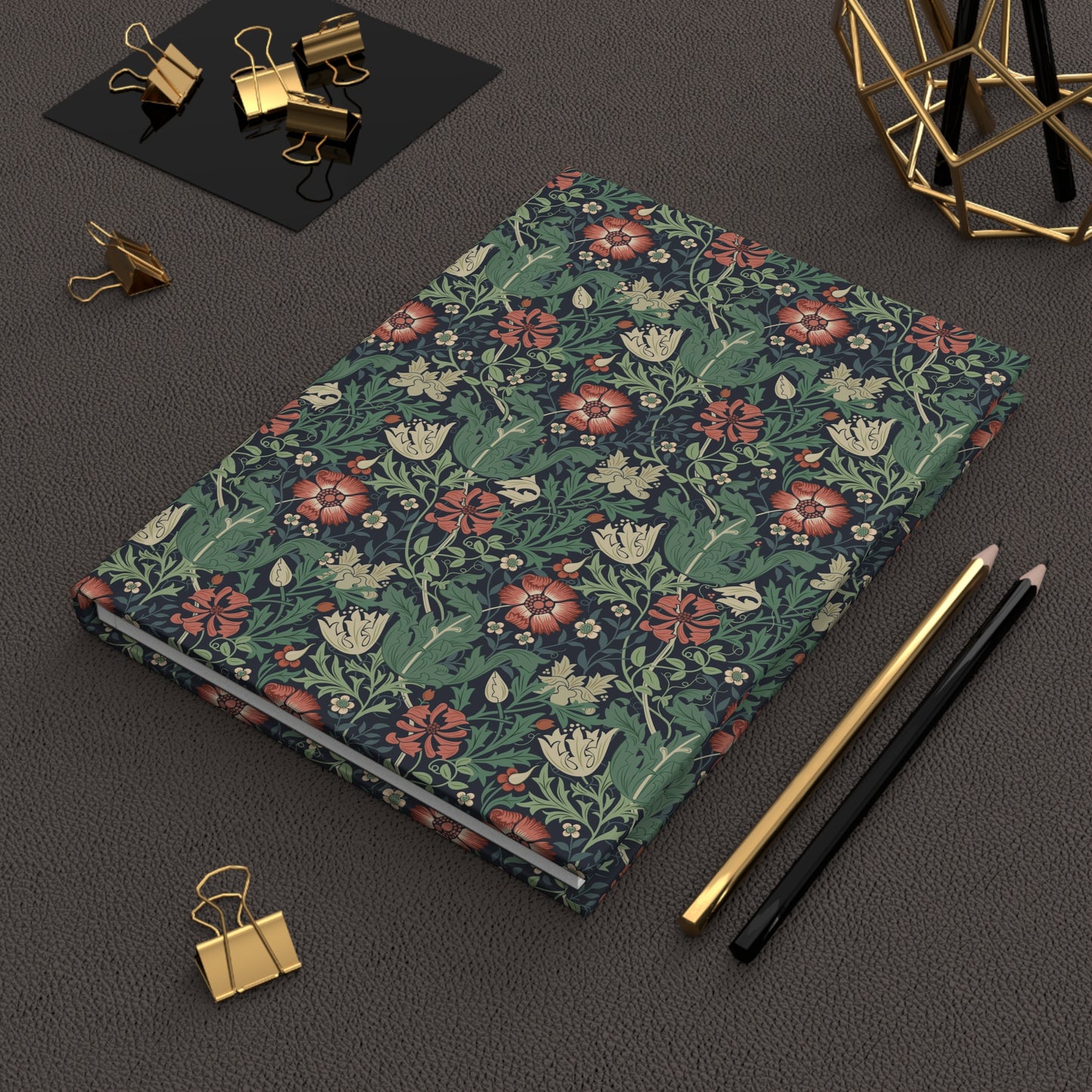 Floral William Morris & Co patterned notebook on a dark surface with office supplies.
