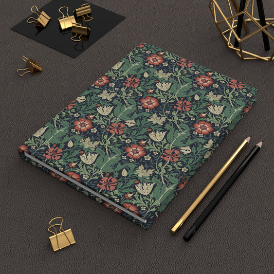 Floral William Morris & Co patterned notebook on a dark surface with office supplies.