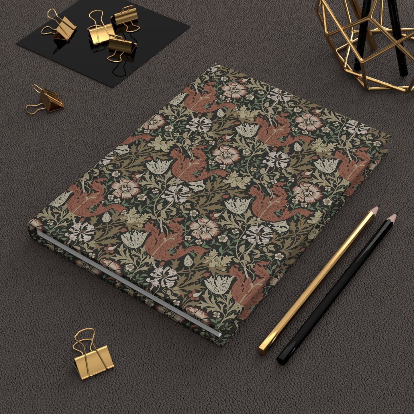 Notebook with William Morris & Co floral and fox pattern on a dark surface with office supplies.
