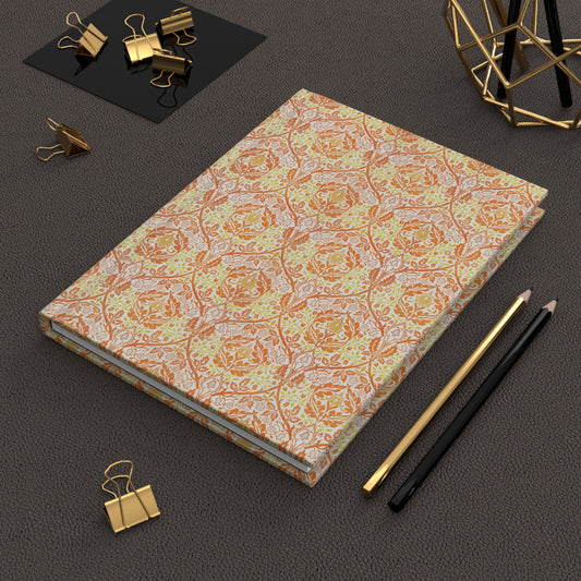 Light orange notebook with text on a dark surface with office supplies