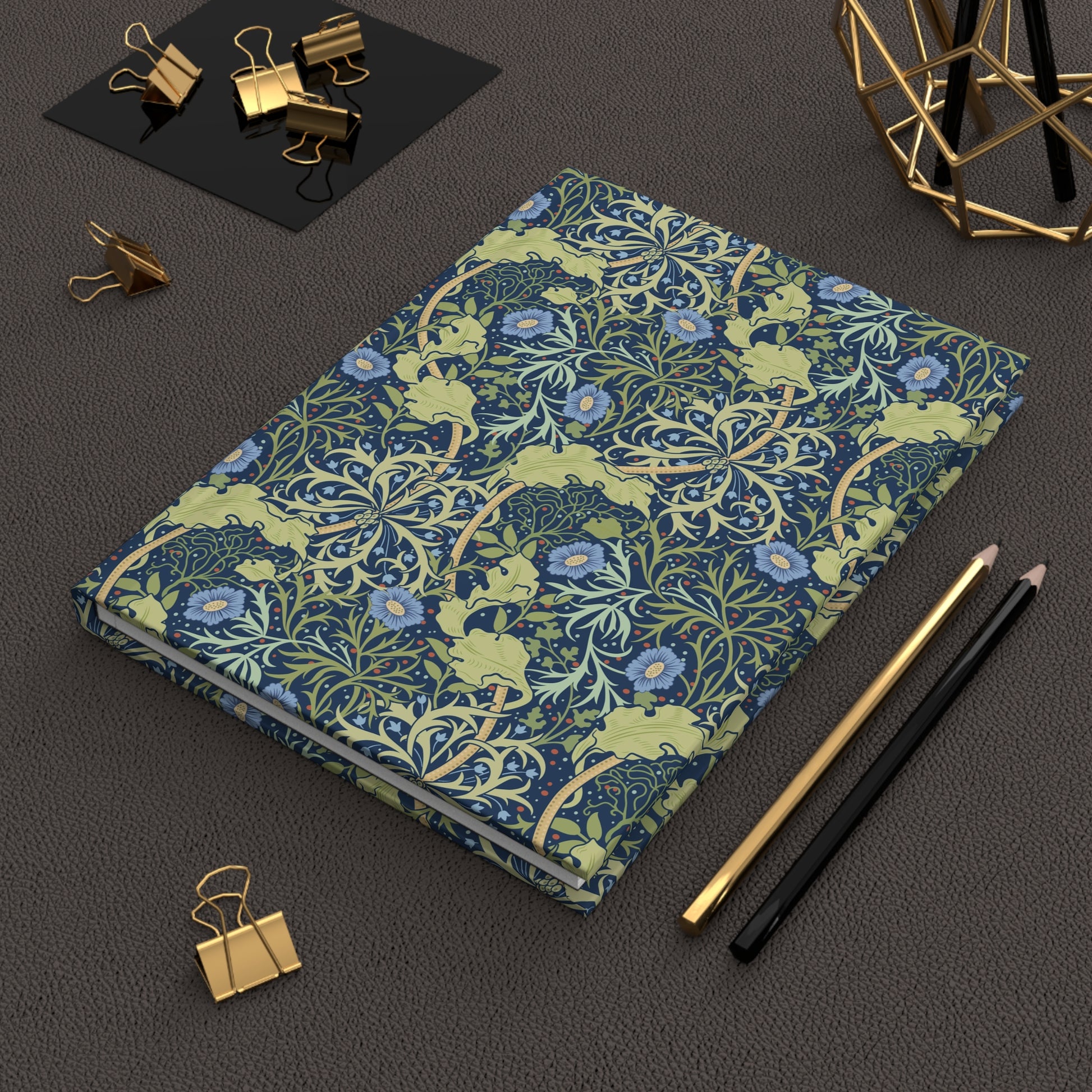 Notebook with William Morris & Co floral pattern on a dark surface with office supplies