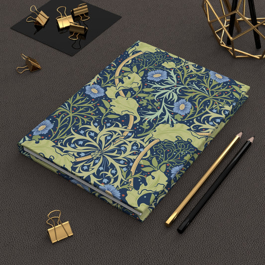 Decorative notebook with floral pattern on a dark surface with stationery items.
