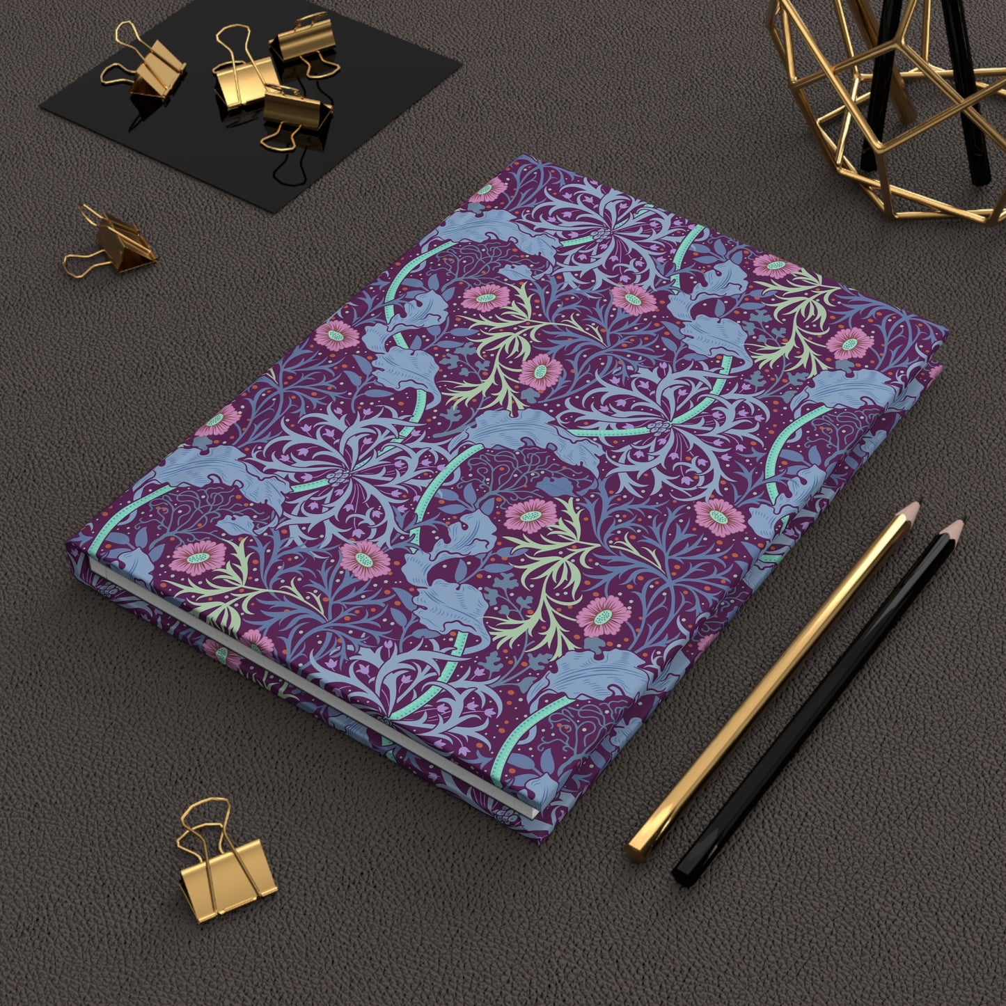 Decorative journal with William Morris & Co floral pattern on a dark surface with office supplies.