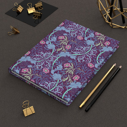 Decorative journal with William Morris & Co floral pattern on a dark surface with office supplies.