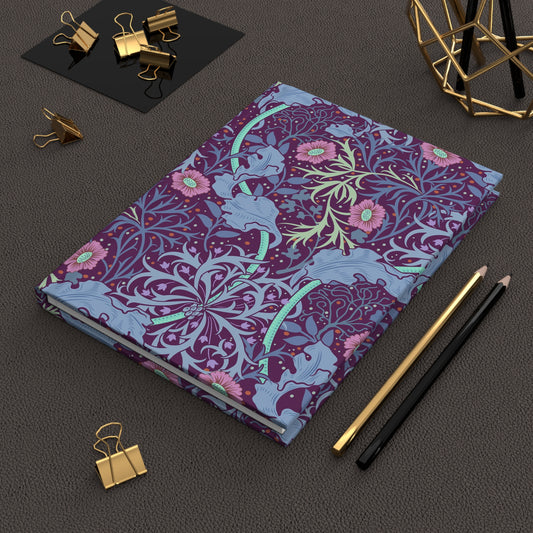 Decorative notebook with floral and animal pattern on a dark surface with office supplies.