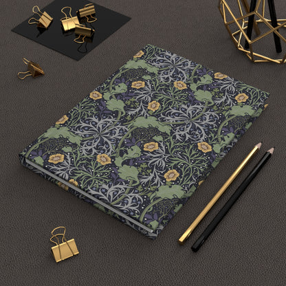 Floral William Morris & Co patterned notebook on a dark surface with office supplies