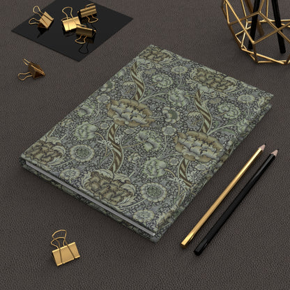 Floral notebook with gold and black office supplies on a dark surface