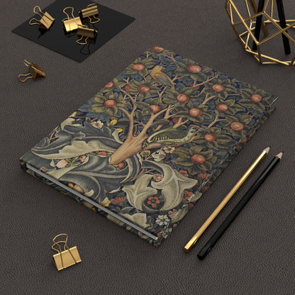 Decorative notebook with artistic cover design on a dark surface with office supplies.