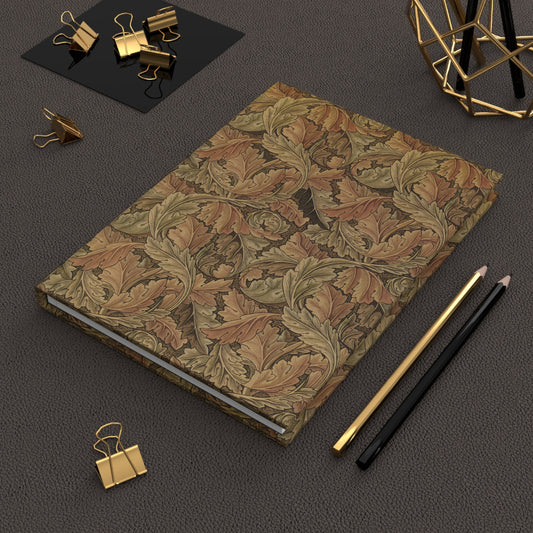 Decorative notebook with leaf pattern on a dark surface with office supplies.