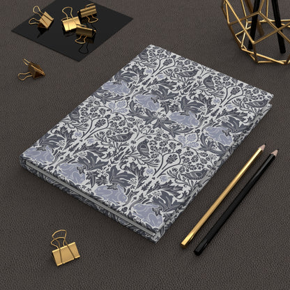 Floral-patterned notebook on a dark surface with office supplies