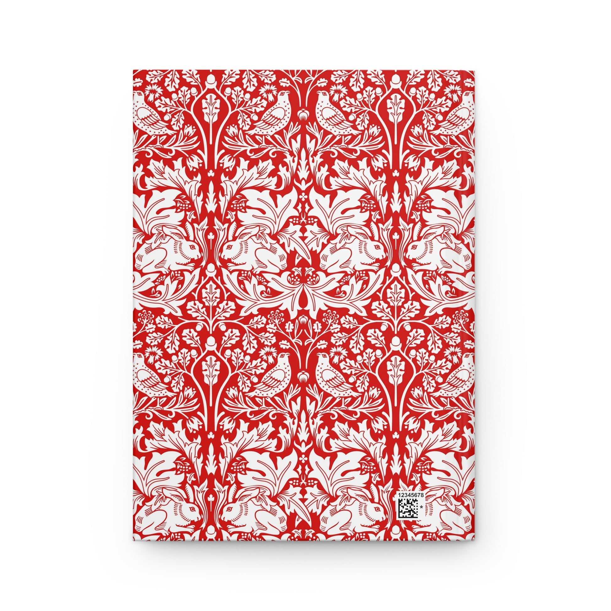 Red notebook with white floral and bird pattern on a white background