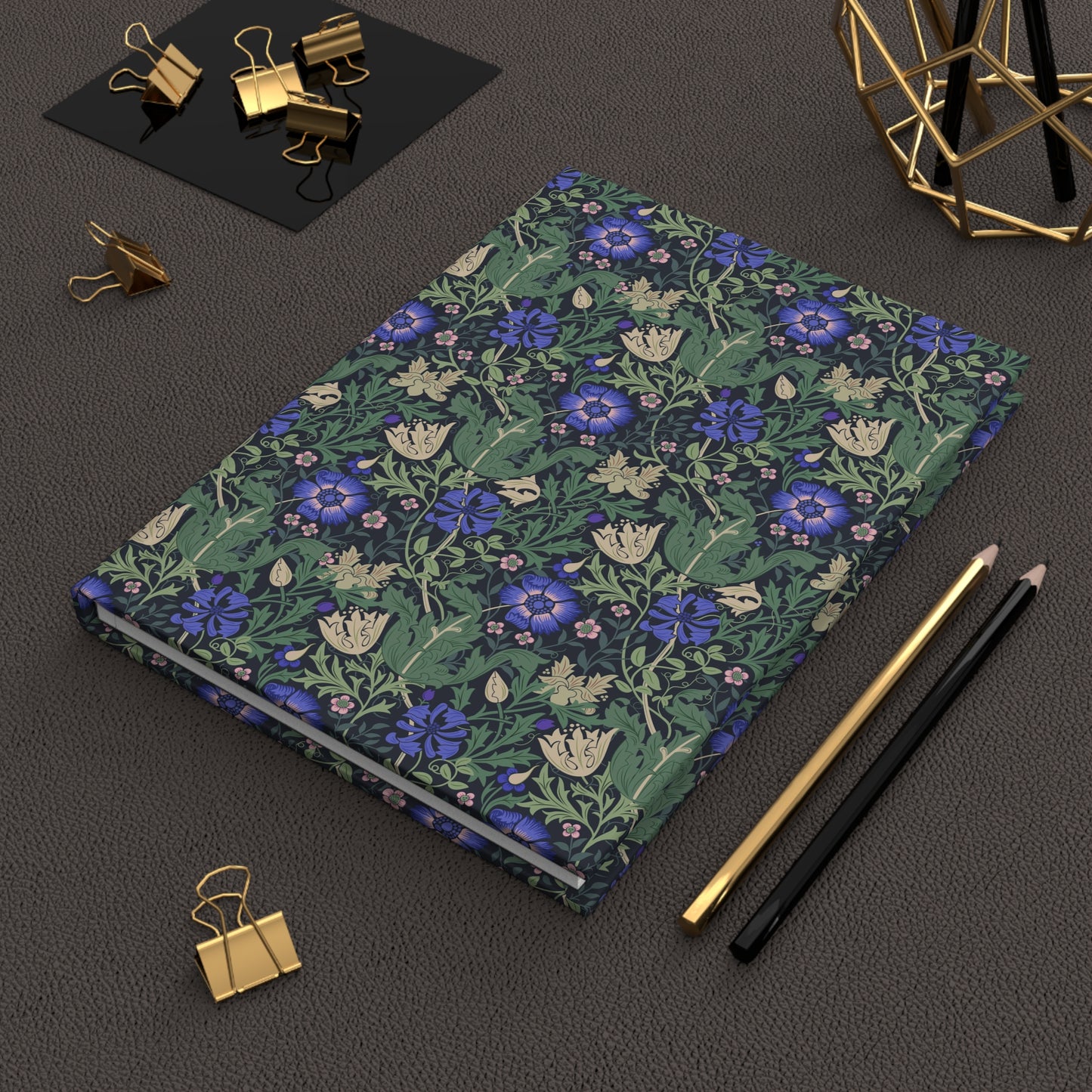 Floral William Morris & Co notebook with stationery items on a dark surface