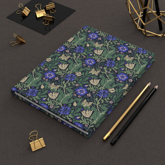 Floral William Morris & Co notebook with stationery items on a dark surface