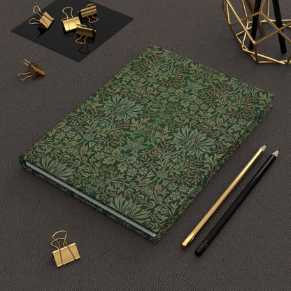 Green patterned notebook with gold and black office supplies on a dark surface