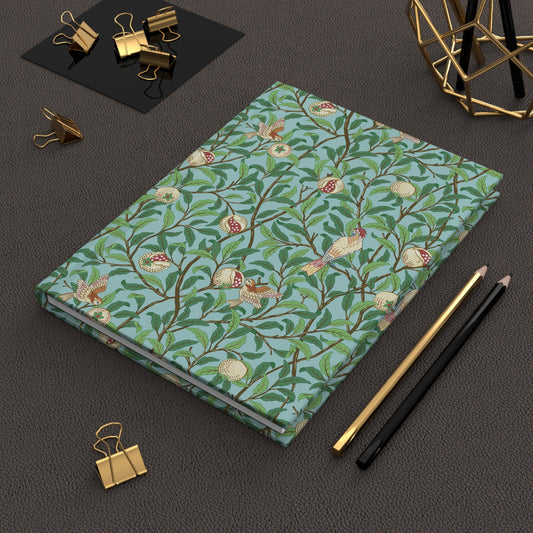 Notebook with floral pattern on a dark surface with office supplies