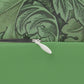 A green lumbar cushion with a floral William Morris & Co pattern, featuring a hidden beige zipper.