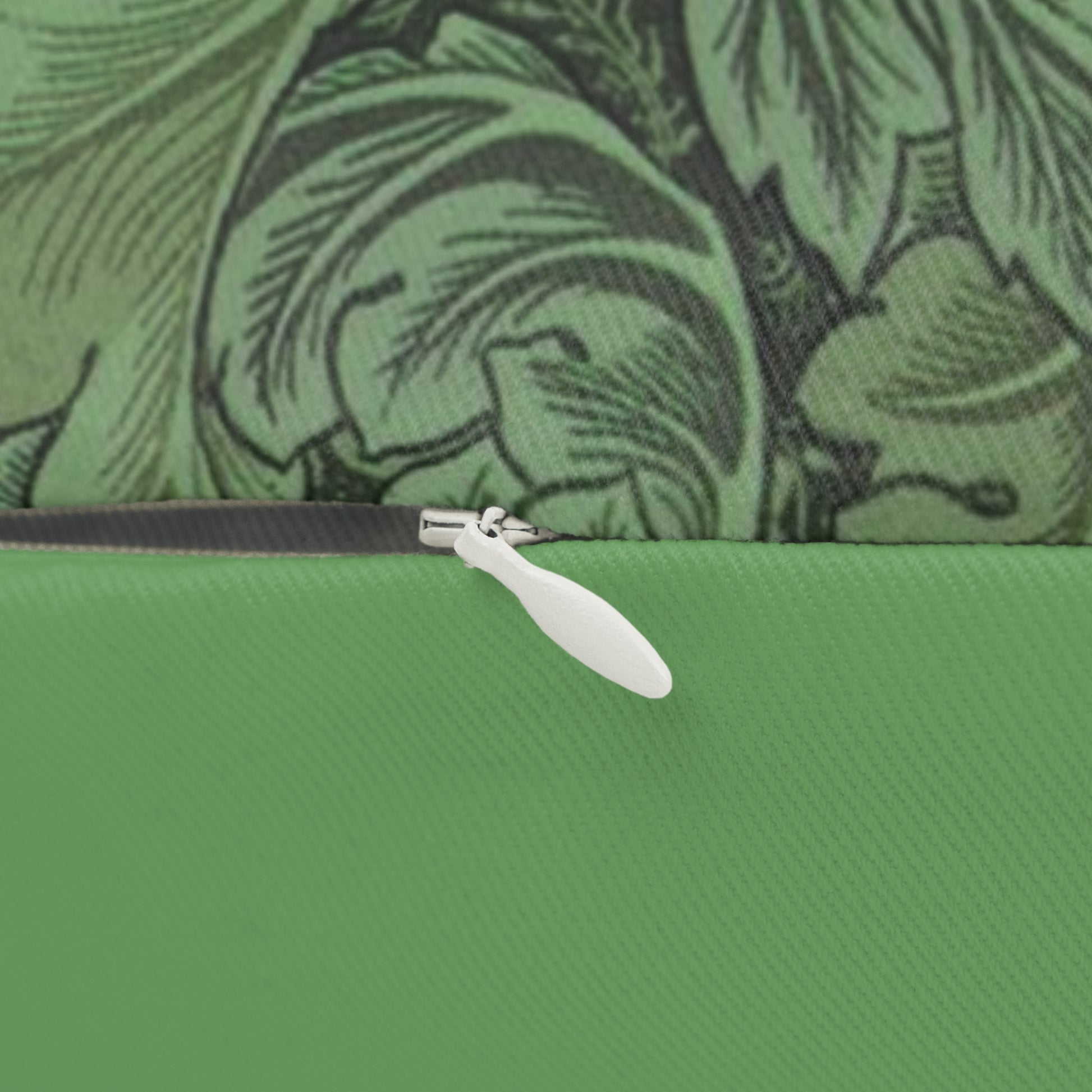 A green lumbar cushion with a floral William Morris & Co pattern, featuring a hidden beige zipper.