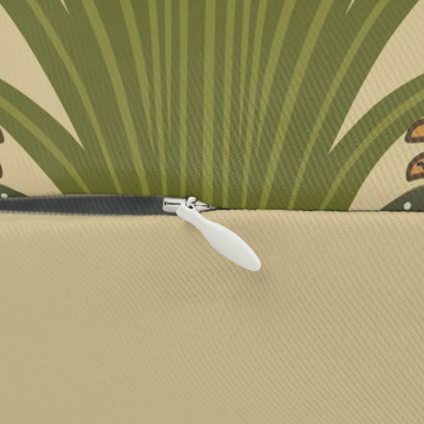 A rectangular lumbar cushion with a black and green William Morris & Co pattern featuring stylised swan figures.