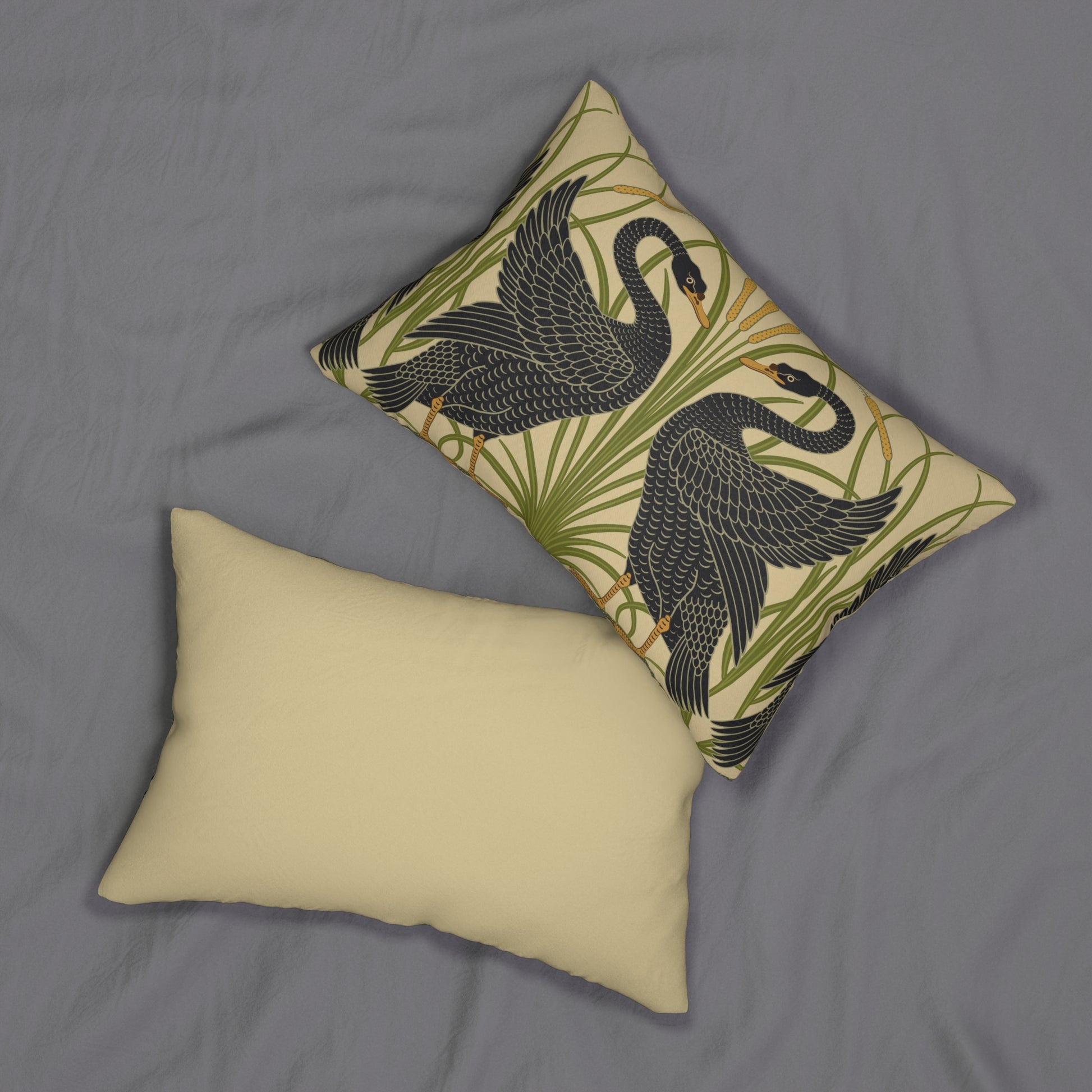 A rectangular lumbar cushion with a black and green William Morris & Co pattern featuring stylised swan figures.
