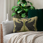 A rectangular lumbar cushion with a black and green William Morris & Co pattern featuring stylised swan figures.