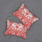 Two square decorative throw pillows with a red and white floral damask pattern, displayed on a gray fabric background.