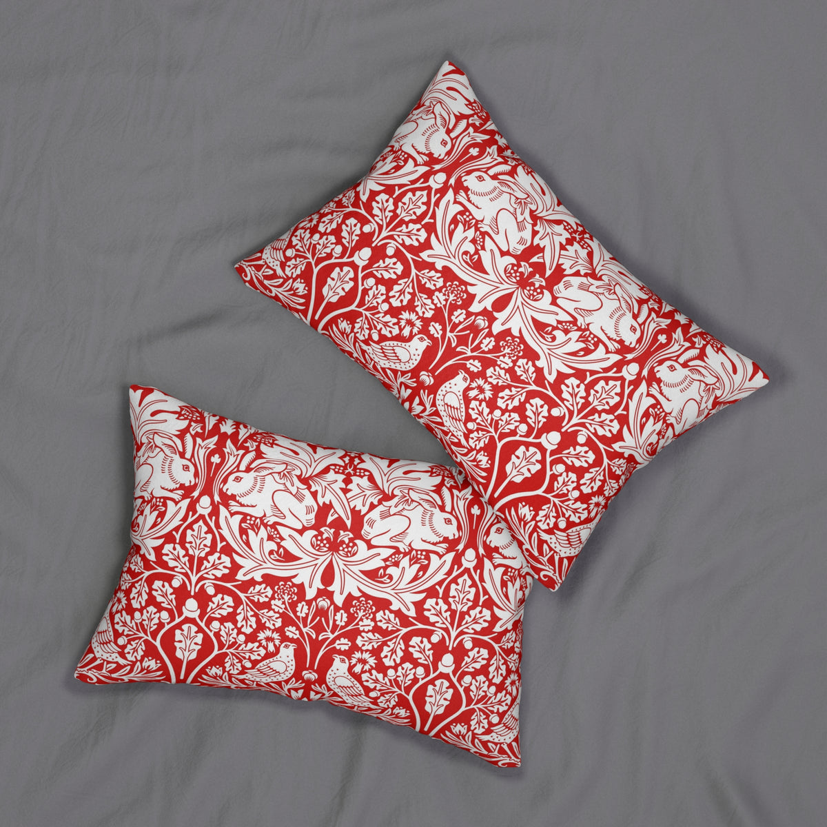 Two square decorative throw pillows with a red and white floral damask pattern, displayed on a gray fabric background.