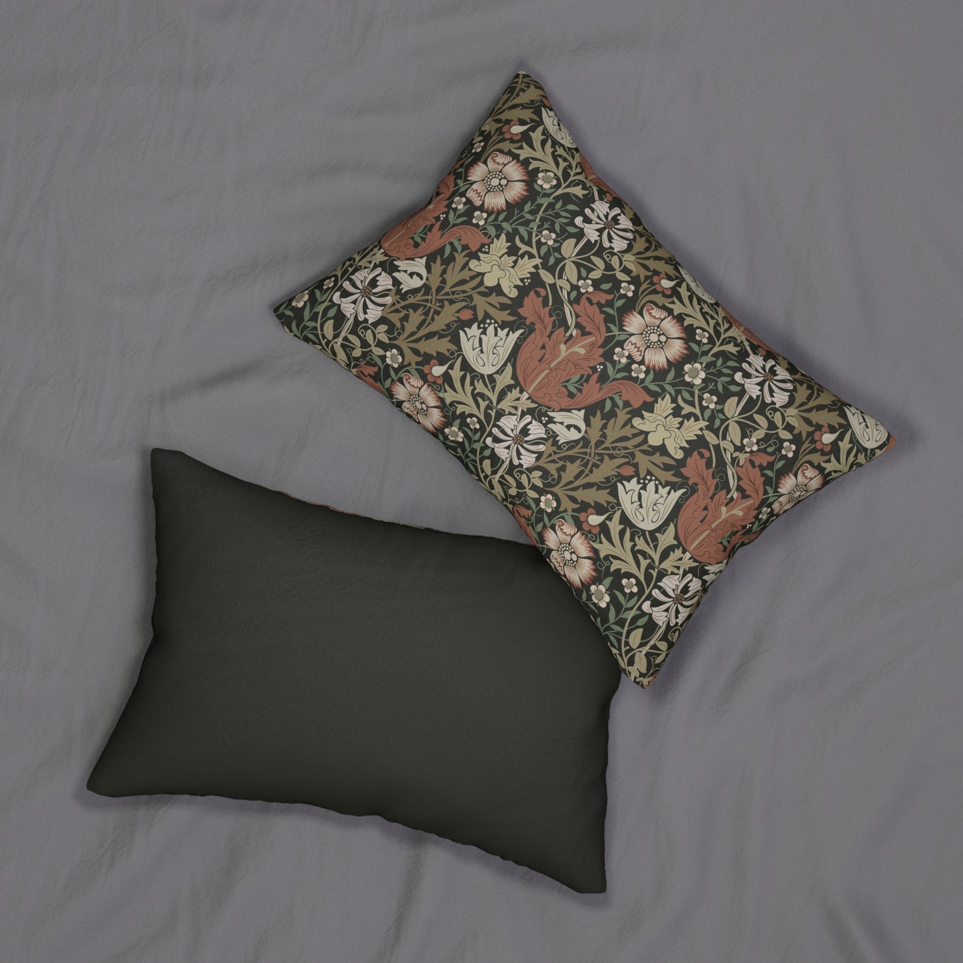 A rectangular William Morris inspired lumbar cushion with a floral pattern in beige, green, and red hues.